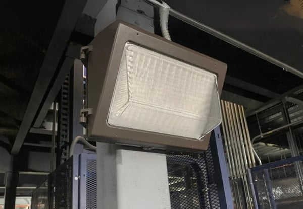 Wall-mounted LED motion sensor light installed above an exterior door