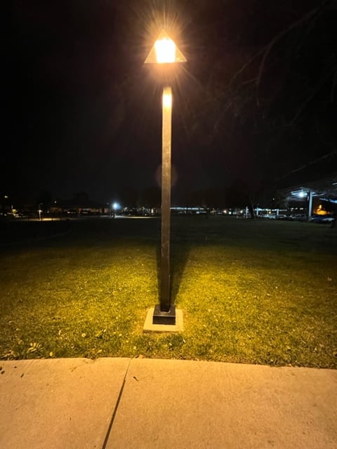 Surface mount light pole base plate on anchor bolts