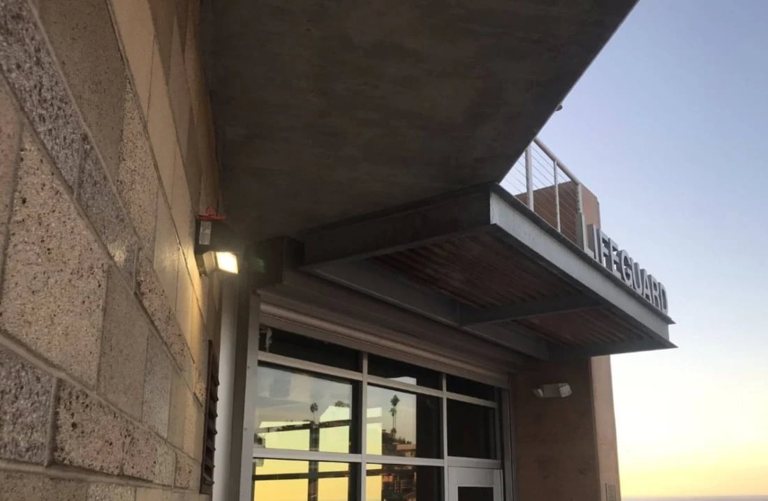adjustable LED wall light with rotating head mounted on building exterior